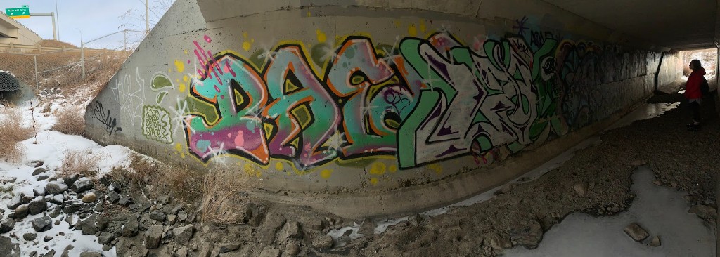 Colourful graffiti inside a concrete underpass, winter light at the tunnel mouth