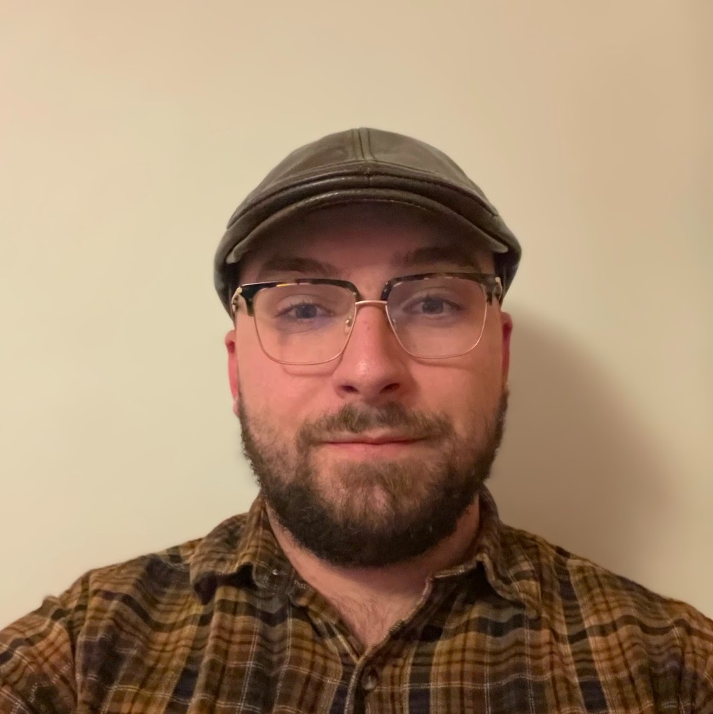 Isaac Klein, headshot with cap and glasses